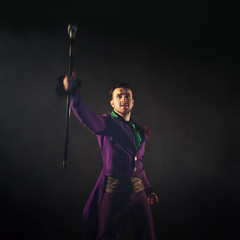 Showman. Young male entertainer, presenter or actor on stage. The guy in the purple camisole and the cylinder.