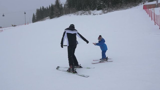 Man teaching boy how to ski