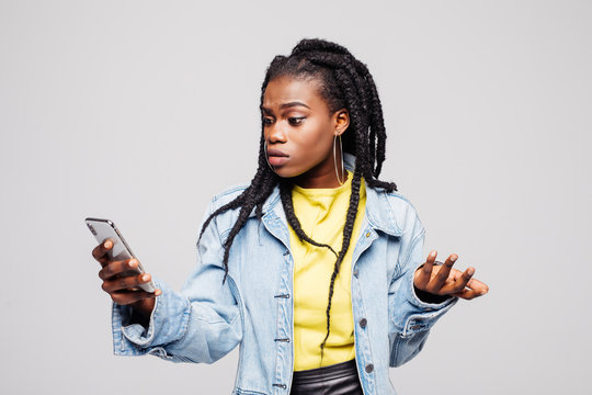 Young afro american woman Look and Writes on the Phone Isolated on a gray Background