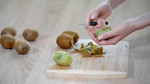 Peeling a kiwi with a knife