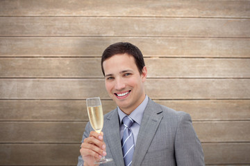 Fototapeta premium Businessman toasting with champagne against wooden surface with planks