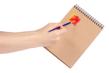 Notepad for drawing and brush with paint in hand