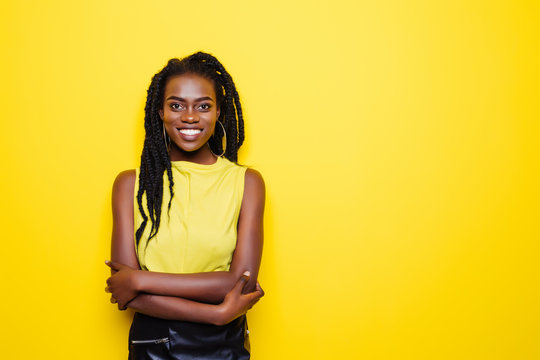 Portrait of smiling woman with dreadlocks in yellow blouse