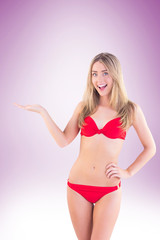 Obraz premium Fit blonde in red bikini showing scales on vignette background