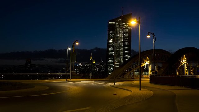 Time lapse of night trafic in front of Frankfurt skyline on a bridge and a roundabout  near the European Central Bank with cars, trucks, pedestrians and cyclists.