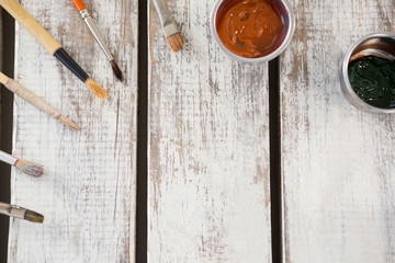 Paintbrushes and watercolors arranged on wooden surface