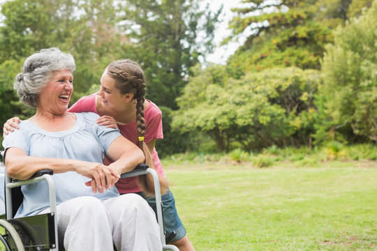 Granddaughter hugging grandmother in wheelchair