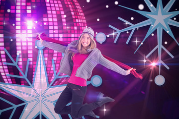 Pretty blonde posing in winter clothes against digitally generated cool disco ball design 
