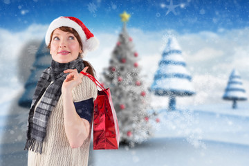 Fototapeta premium Smiling woman wearing santa hat against blurry christmas scene