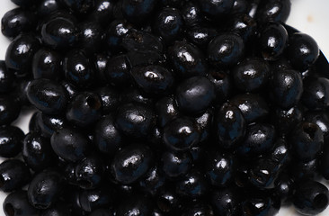 Black olives background, close-up. Healthy vegetarian food, top view