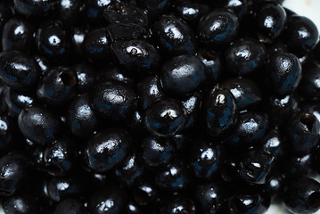Black olives background, close-up. Healthy vegetarian food, top view