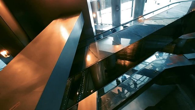 Modern futuristic glassed escalators with people