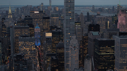 AERIAL: New York City skyscrapers and busy streets lit up with lights at night