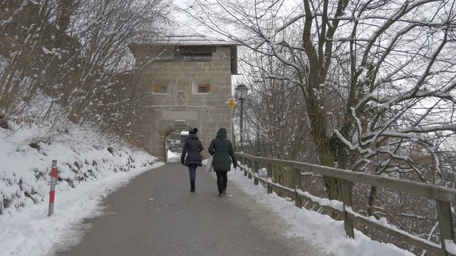 Two women walking on an alley on a winter day