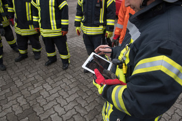 Feuerwehrmann hält ein Tablet in der Hand