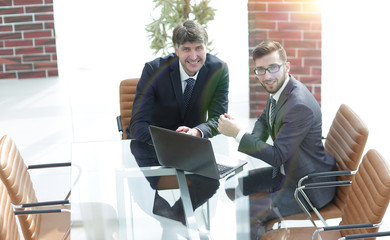 Portrait of business colleagues sitting at work desk