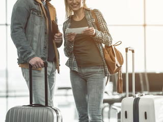Outgoing girl showing ticket to comrade. Happy couple during trip concept