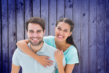 Cute couple smiling at camera against wooden planks background