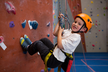 Portrait of determined boy practicing rock climbing