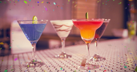 Various cocktails drinks on bar counter against flying colours