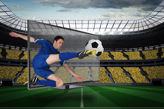 Composite image of fit football player kicking ball through tv against vast football stadium with fans in yellow