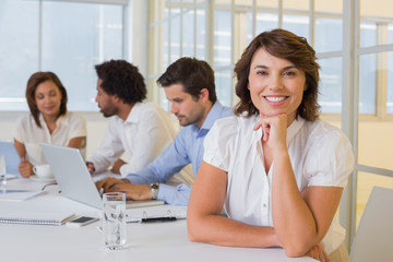 Smiling businesswoman with colleagues in meeting at office