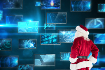 Santa looks away from the camera against screen collage showing computing images