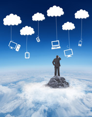 Mature businessman looking and considering against mountain peak through the clouds