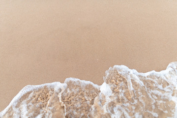 Fototapeta na wymiar Soft Wave of the sea on the sand beach.Selective focus.