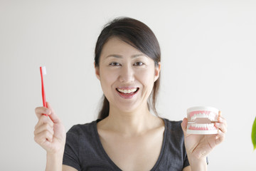 笑顔で歯ブラシを持つ女性
