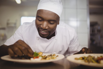 Chef garnishing meal on counter