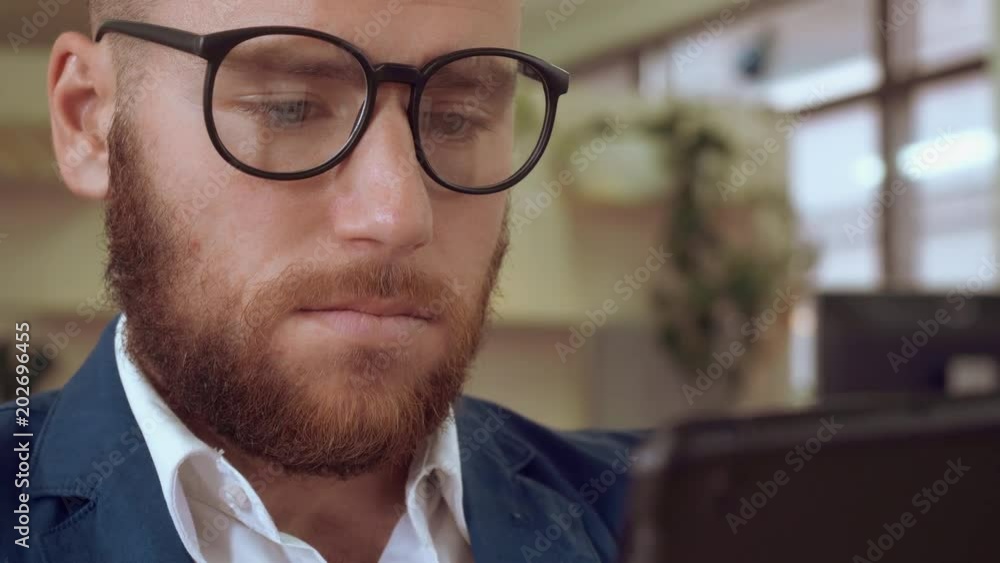 Poster close up portrait handsome man with beard using touch screen digital tablet. businessman scrolling reading news or shoping online