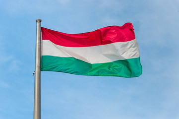Fototapeta na wymiar Hungarian national flag over blue sky