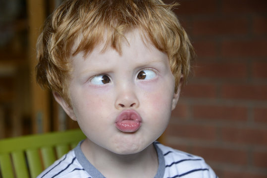 Closeup of young red haired boy doing a silly face