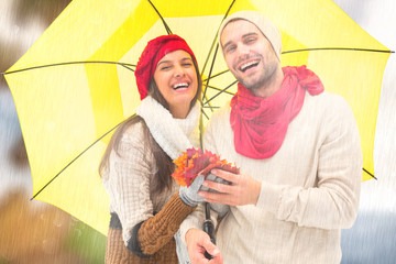 Autumn couple holding umbrella against autumn turning to winter © vectorfusionart