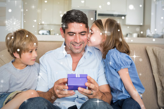 Composite image of Loving children gifting father against snow falling