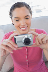 Happy woman sitting on sofa and taking a picture