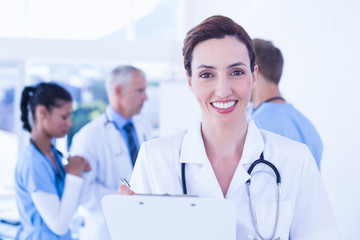 Confident female doctor holding clipboard 