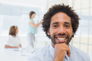 Smiling businessman with colleagues in meeting at office