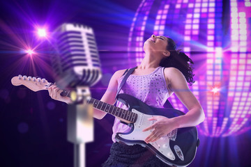 Obraz na płótnie Canvas Pretty girl playing guitar against digitally generated cool disco ball design 
