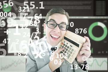 Geeky smiling businessman showing calculator against business interface with graphs and data