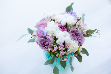 Beautiful bridal bouquet made of purple roses, white carnations,cotton flowers, rose bouvardia and eucalyptus in a vase isolated on a white background