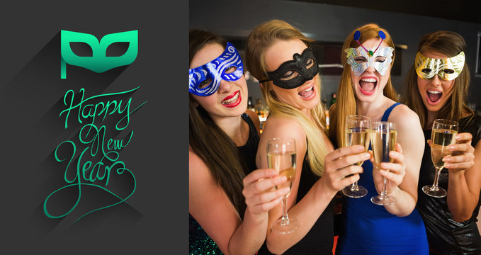 Attractive friends with masks on holding champagne glasses against classy new year greeting