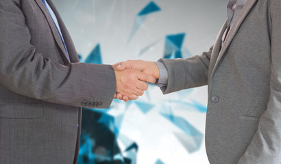 Close up on two businesspeople shaking hands against angular design