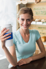 Smiling woman with coffee sipper in coffee shop