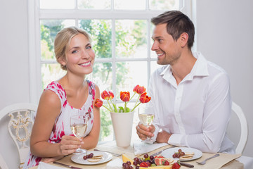 Obraz na płótnie Canvas Happy couple with wine glasses having food