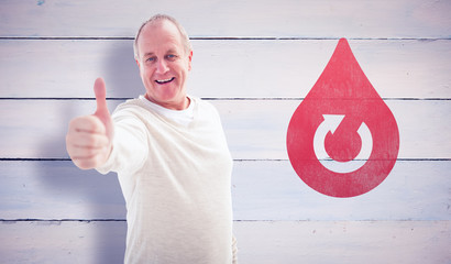 Happy mature man showing thumbs up to camera against painted blue wooden planks