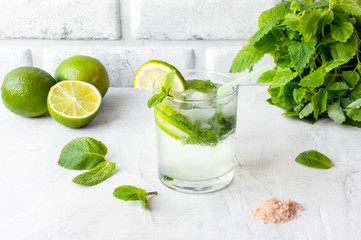 Fresh Cold Mojito Cubano Cocktail with lime and mint on a concrete table. Side view. 