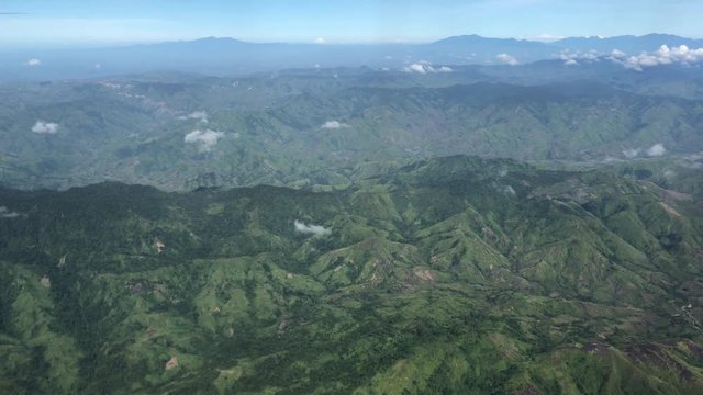 Handheld aerial view of mountains and valleys in the southern Philippines Seen from an airplane window above Bukidnon mountains