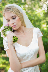 Content bride holding her bouquet wearing a veil